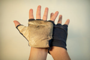 A set of protective gloves-worn while carving away a wooden boat in A Kiss For Luck performance