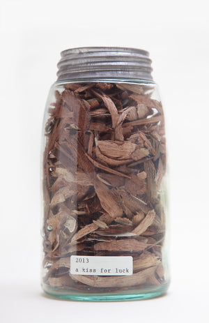Vintage mason jar filled with wood shavings, collected from A Kiss For Luck performance