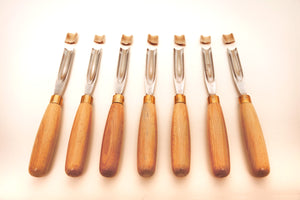 James Leonard - a spread of seven carving knives on white surface, tools used in A Kiss for Luck