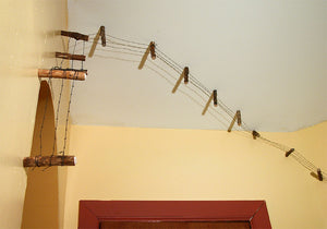 James Leonard - A detail image of handmade barbed wire in Running Fence no. 1; photo showcases an installation where the fence runs up a wall and across the ceiling 