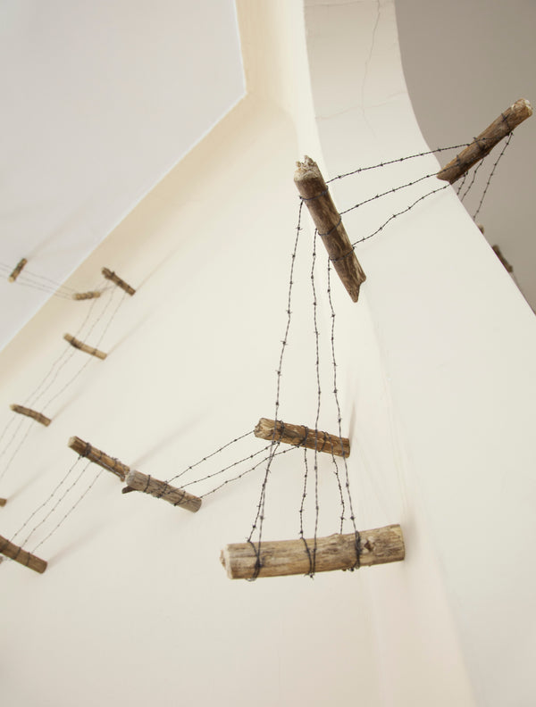 James Leonard - A handmade, tiny barbed wire fence, Running Fence no. 4, installed in a private home
