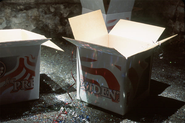 James Leonard - Detail of open boxes from installation of Hopeful, which include print graphics that read J: for President