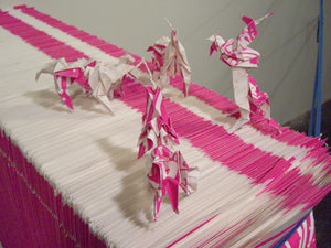 James Leonard - A photo of Hungry Dust from above, looking down on four pink origami unicorns