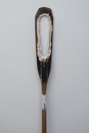 James Leonard - Wide shot of Untitled Oar no. 4, depicting gaping chemical hole cutting through a painted black paddle; a white stripe is painted at the neck