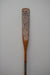 James Leonard - Untitled Oar no. 6 perched upright, with its paddle's varnish worn down to showcase a sandy color and small holes spread across in constellation