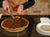 James Leonard - Image of a slice of pie about to be moved onto a patterned plate, for the participatory piece, My Mother's Dutch Apple Pie 