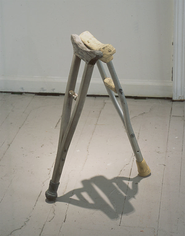 James Leonard - A pair of miniature fabricated crutches propped up against each other named, Two Monkeys Cudgel, are installed on the floor of a gallery space