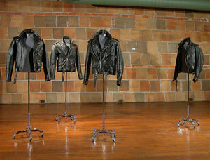 James Leonard - Front view of the installation, Warlords, which showcases four leather jackets, each installed on their own chrome plated dress stand; two coats are zipped and two lay open at the chest