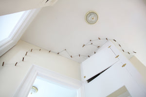 James Leonard - Wide shot of Running Fence no. 5, looking upwards at the long trail of miniature barbed wire fencing attached to the ceiling