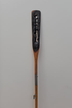 James Leonard - Full frame image of Untitled Oar no. 5, displaying a lean, burnt paddle and metal hardware towards the base of the stem